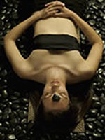Woman on dark stones massage
